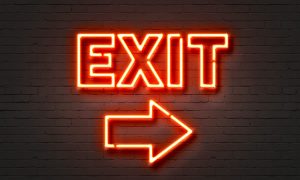 Exit neon sign on brick wall background